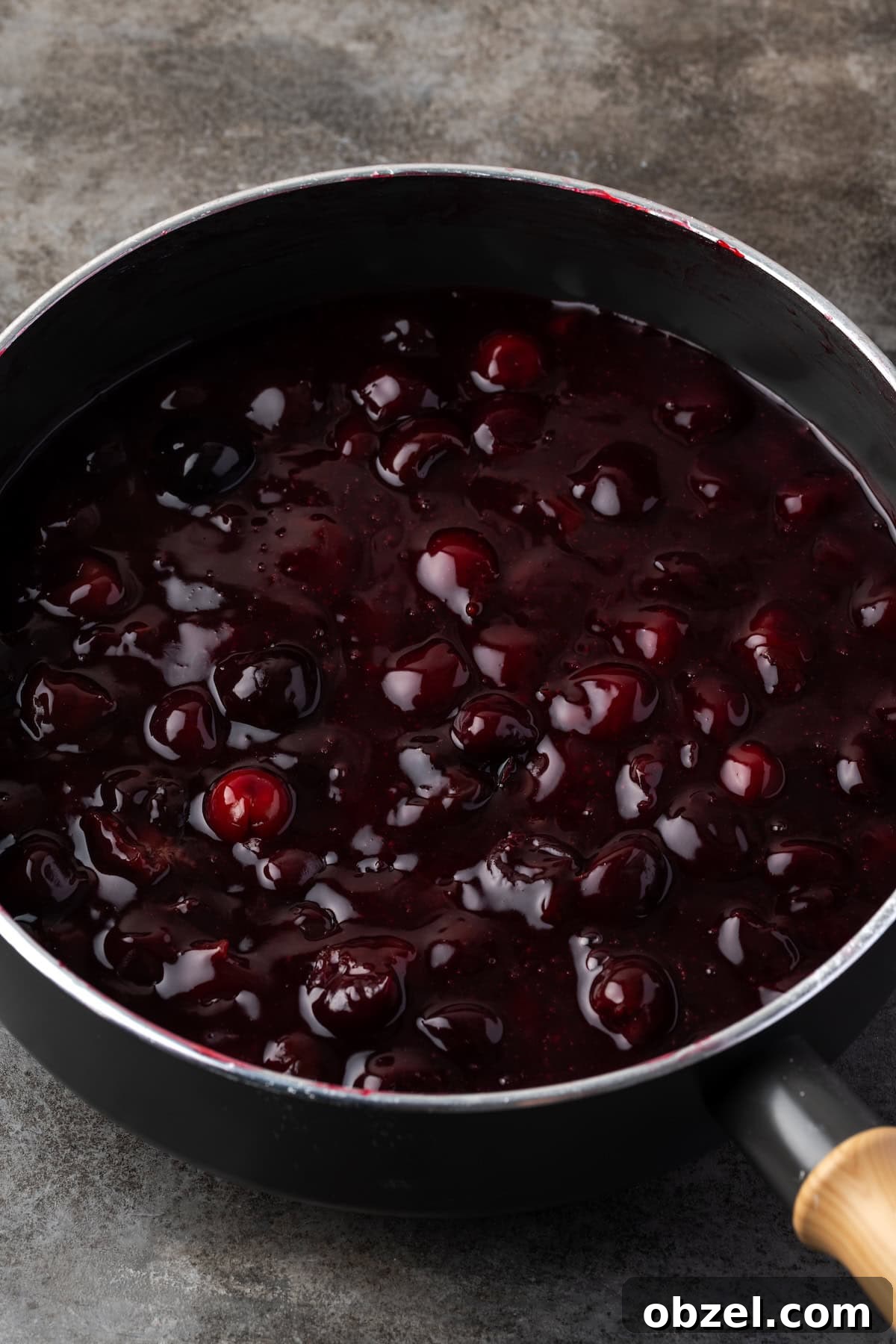 Homemade cherry pie filling simmering in a saucepan. Homemade cherry pie filling in a saucepan.
