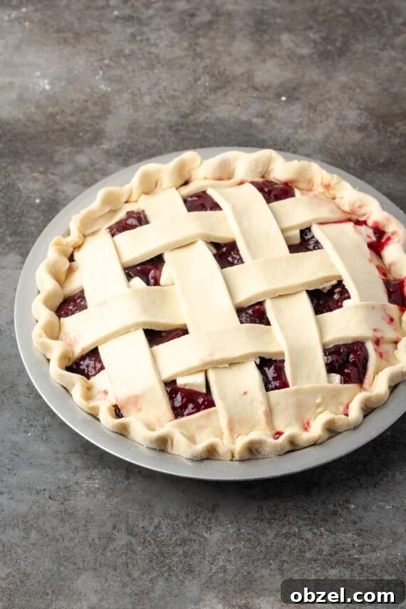 Unbaked cherry pie with lattice crust. An unbaked cherry pie with fluted edges topped with a lattice crust.