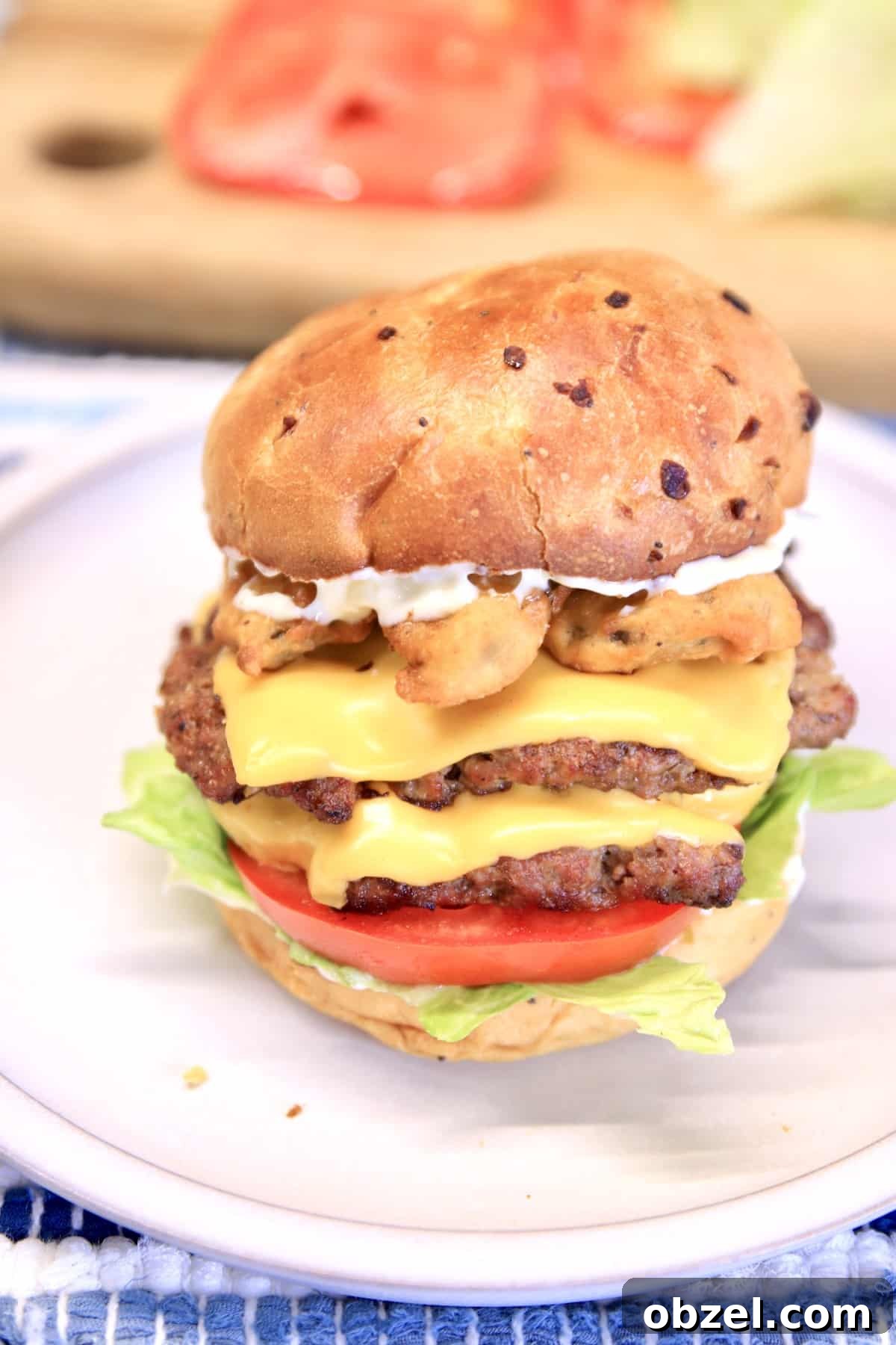 Grilled cheeseburgers with fried pickles on onion buns. Onion bun double cheeseburger with fried pickles.