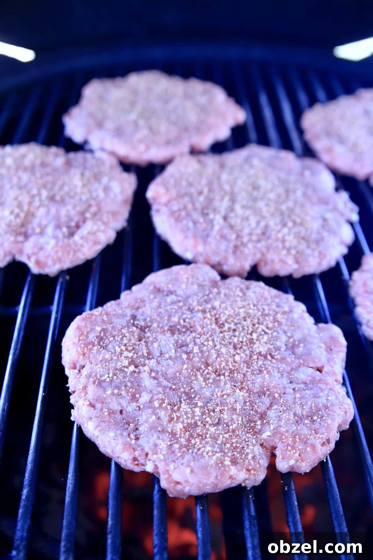 Grilling burgers for Double Cheese Fried Pickle Burgers. Burger patties on a grill.