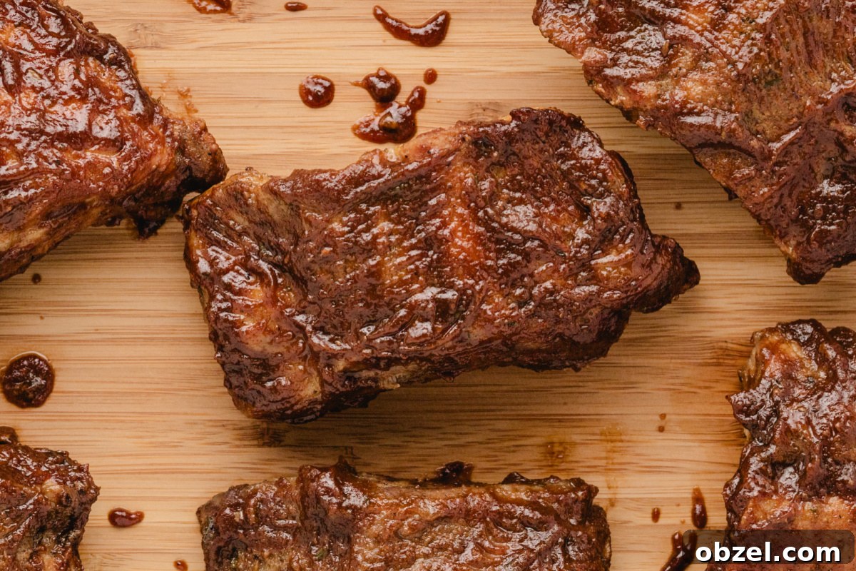 Juicy Slow Cooker Baby Back Ribs Recipe 8 baby back ribs with sauce on a board
