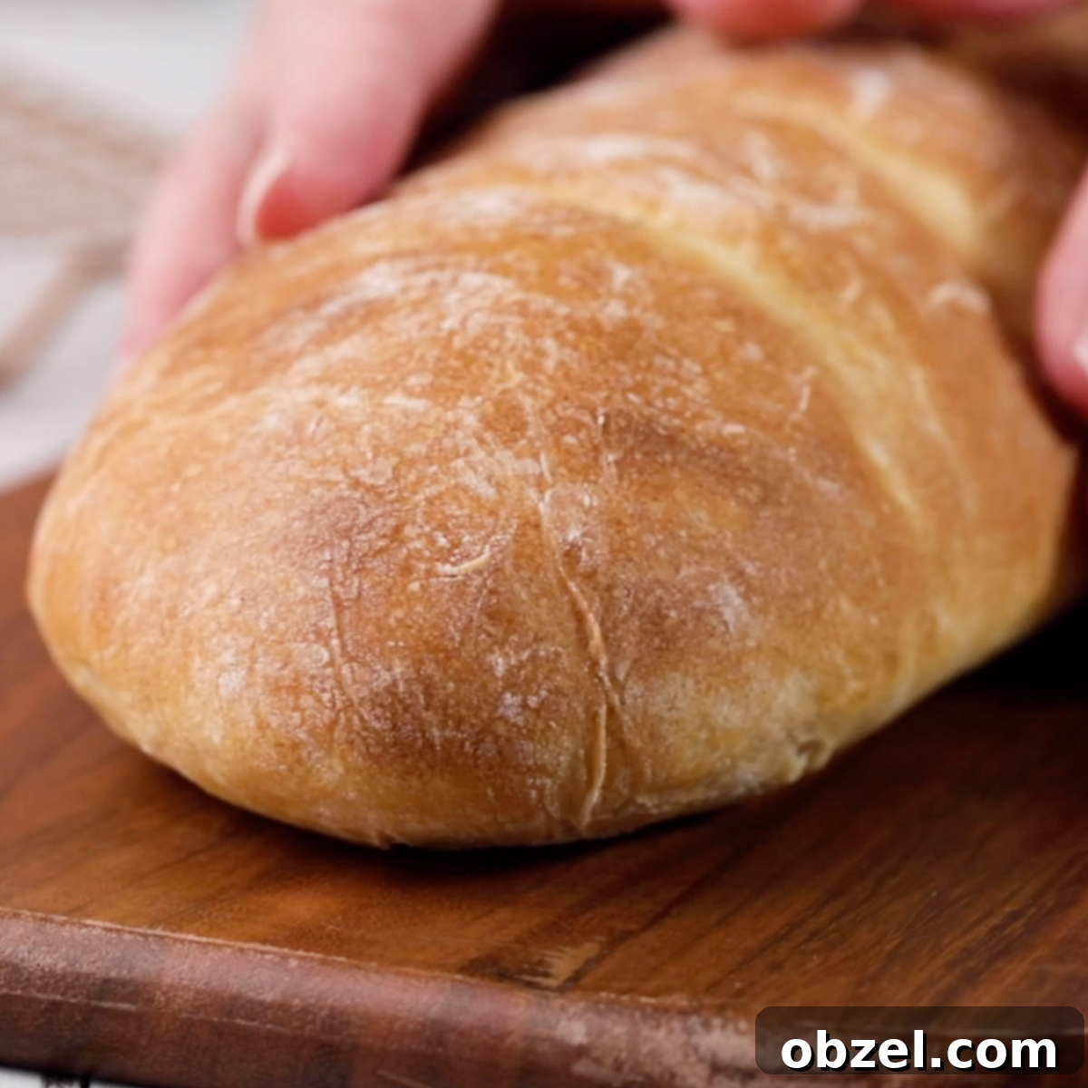 Front view of a baked loaf of Italian Bread sitting on a cutting board - Hostess At Heart