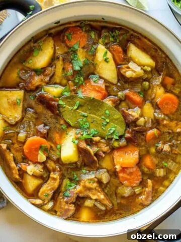 A large casserole dish with potatoes and carrots stewed in a brown sauce.