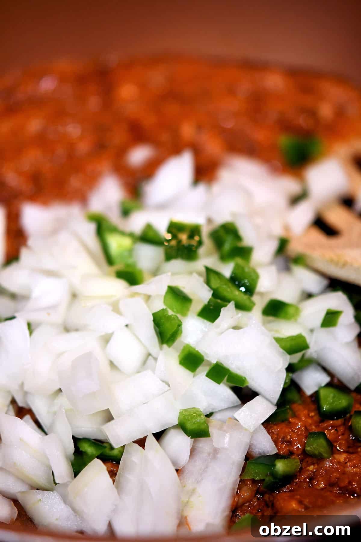 Mexican Chorizo and Potato Breakfast Skillet 6 close up of skillet with uncooked onions and bits of jalapeno
