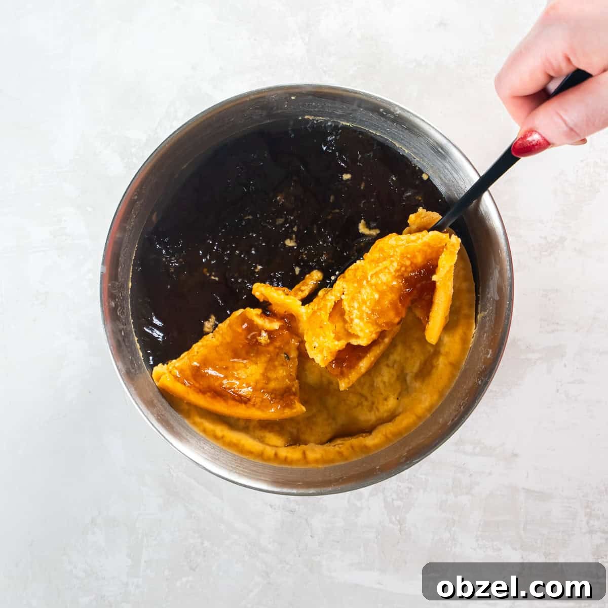 Slow Cooker Pulled Pork Recipe 10 Solidified fat being lifted from chilled cooking liquid with a spoon.