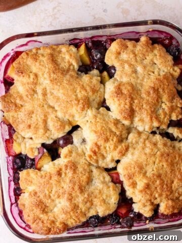 Peach and blueberry cobbler in a square glass baking dish
