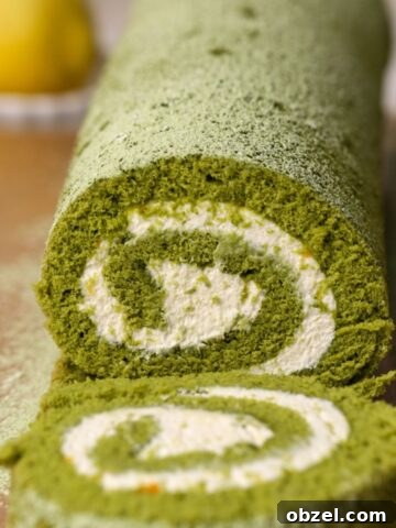 A matcha cake roll with mascarpone filling being sliced