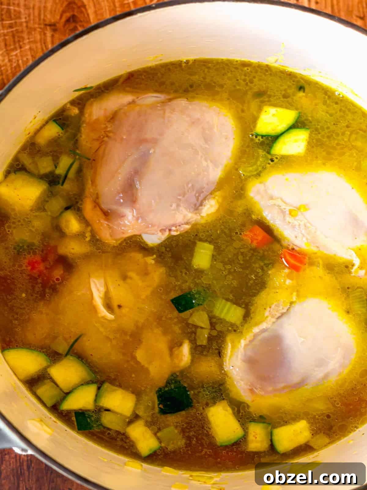 Homemade Bone-In Chicken Soup Recipe with Rich Broth 7 A large pot filled with chicken thighs and broth.