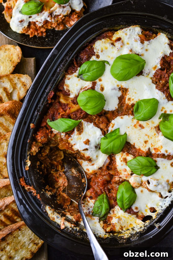 Crock Pot Lasagna Recipe with Meat Sauce 12 Cooked crock pot lasagna with mozzarella and basil after serving.