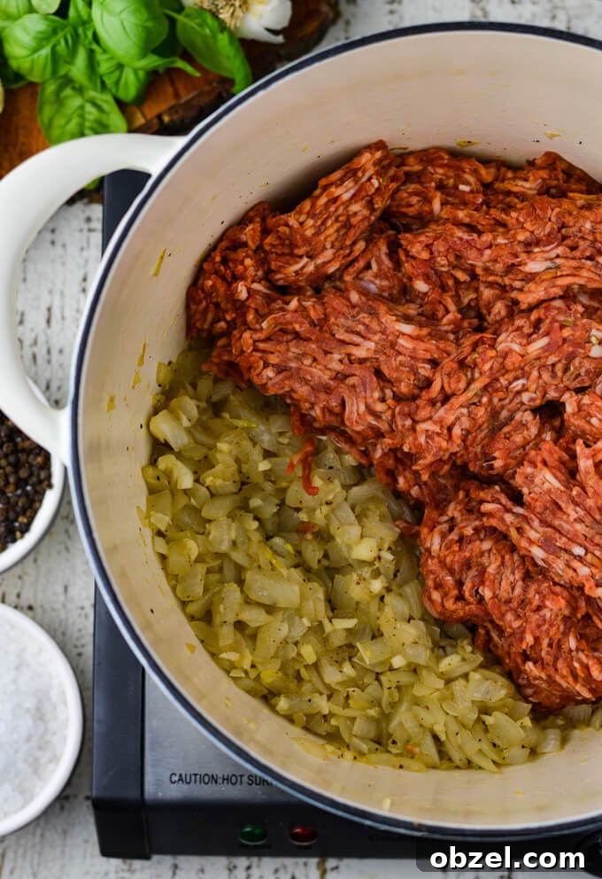 Crock Pot Lasagna Recipe with Meat Sauce 4 Italian sausage added to sautéed onions and garlic in a Dutch oven.