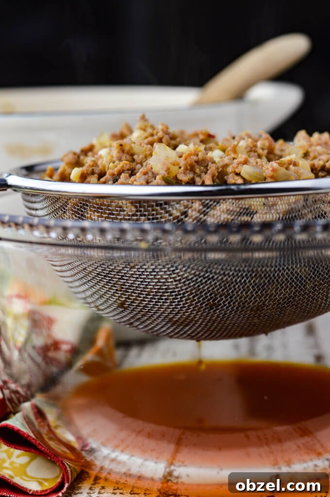 Crock Pot Lasagna Recipe with Meat Sauce 5 Cooked sausage draining in a mesh strainer.