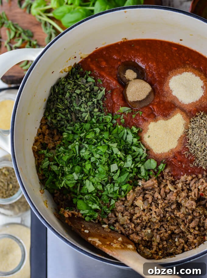 Crock Pot Lasagna Recipe with Meat Sauce 6 Crushed tomatoes, cooked sausage, fresh herbs, and seasonings in a Dutch oven.