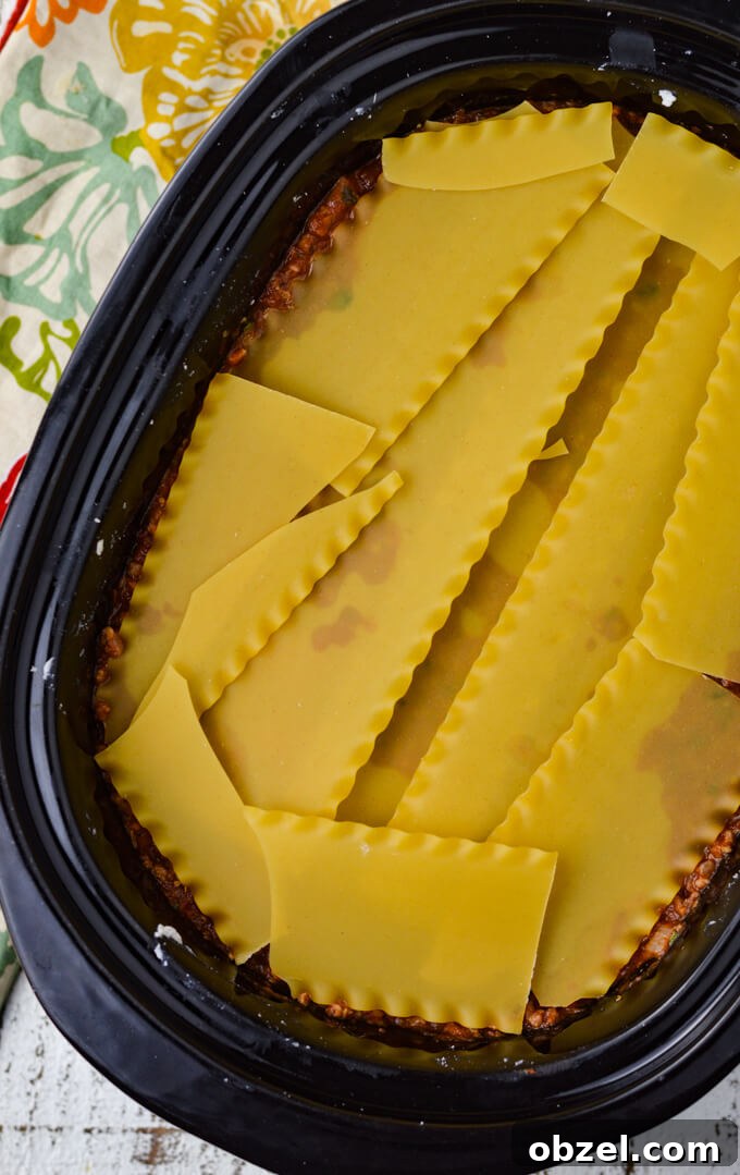 Crock Pot Lasagna Recipe with Meat Sauce 9 Dry lasagna noodles layered in a crock pot with meat sauce.