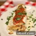 Crispy Fried Chicken Burritos with Creamy Slaw 5 Chicken burrito with sour cream sauce and salsa, end removed to see filling.