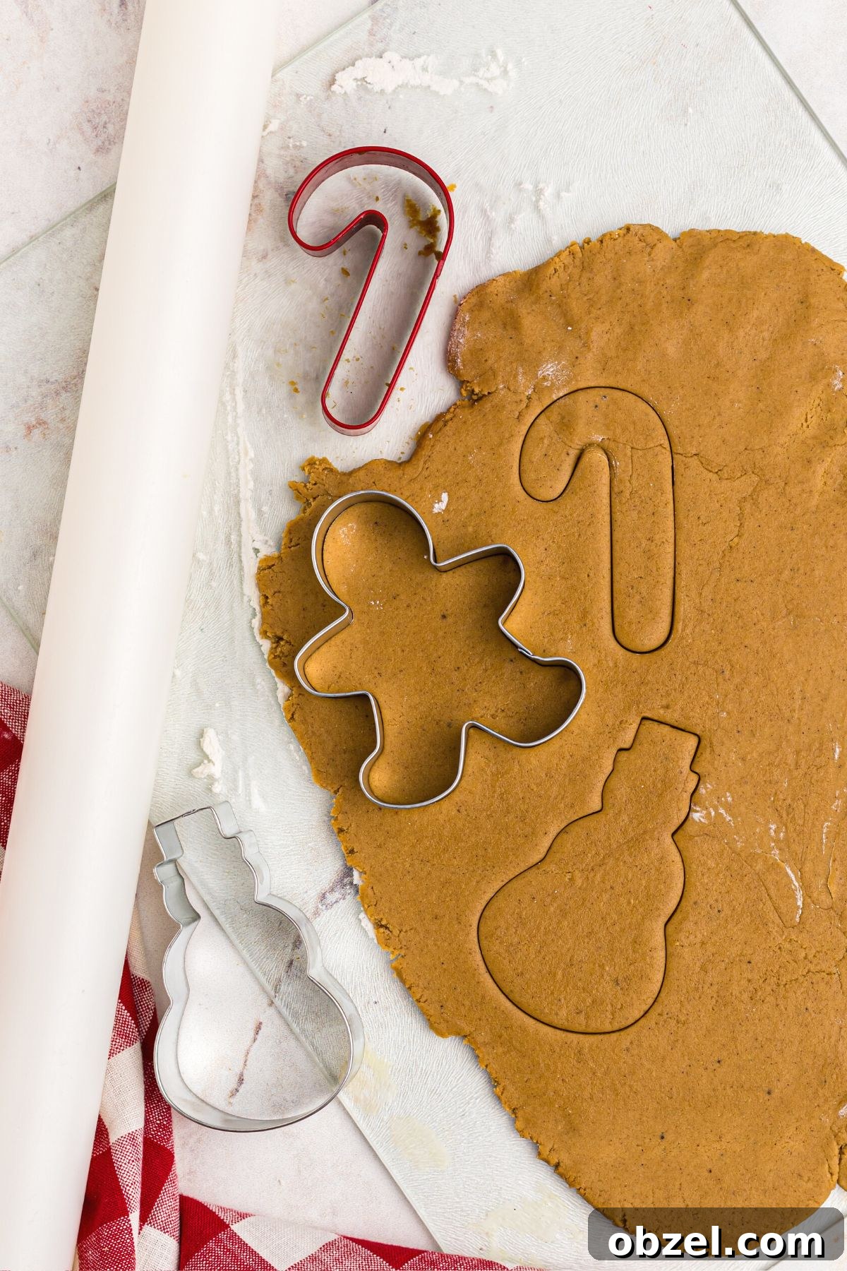Air Fryer Gingerbread Cookies Recipe 8 Golden dough rolled out with a cookie cutters and a rolling pin on table