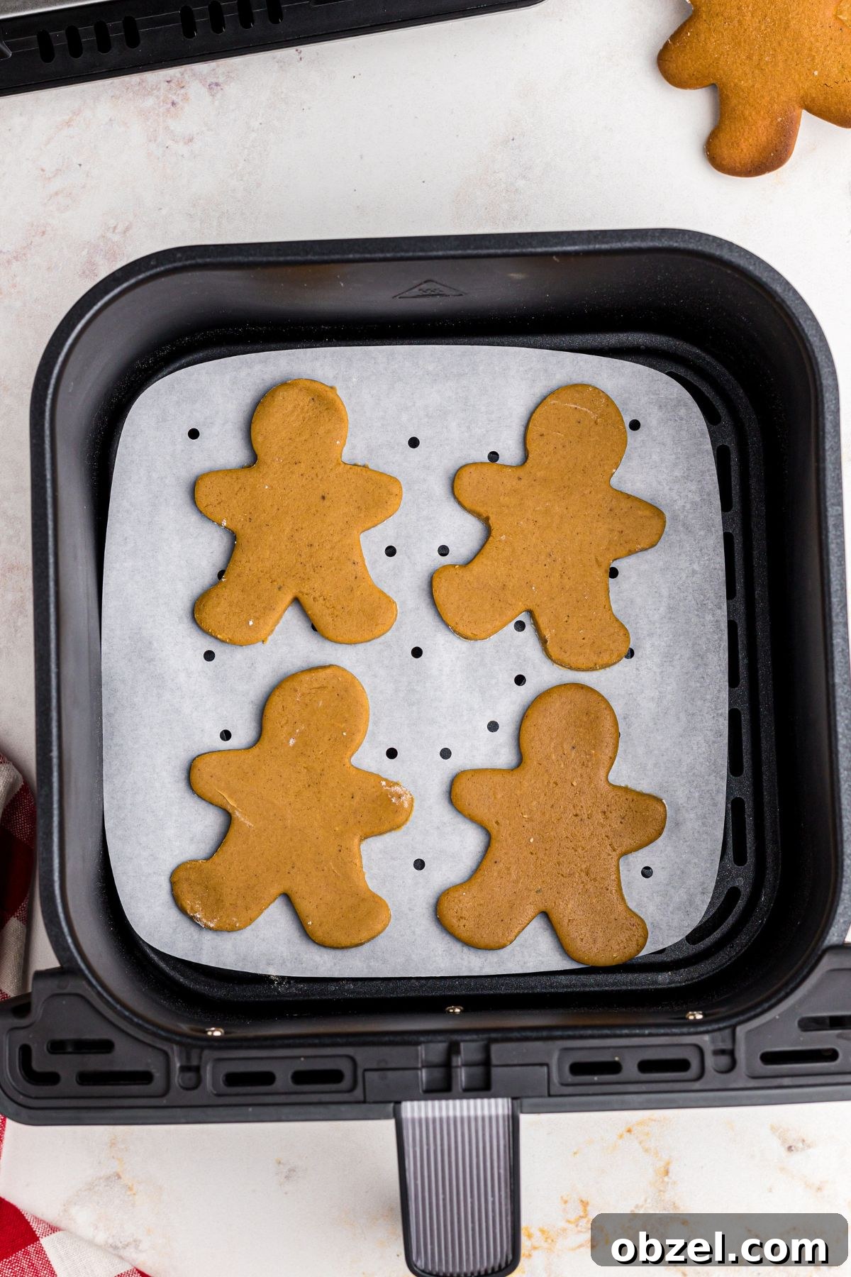 Air Fryer Gingerbread Cookies Recipe 9 Uncooked gingerbread men in an air fryer basket