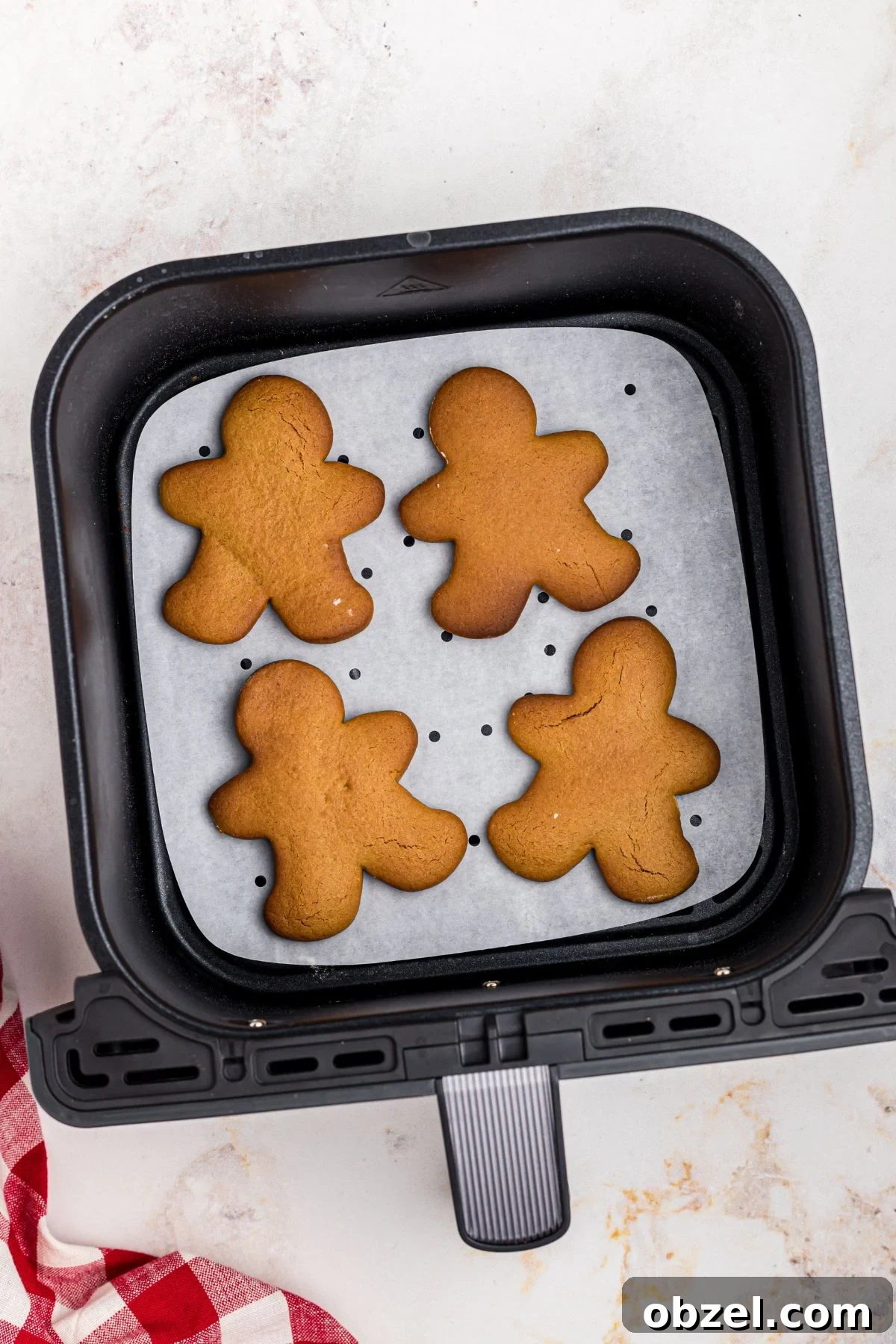 Air Fryer Gingerbread Cookies Recipe 10 Golden gingerbread men cookies in an air fryer basket after being cooked