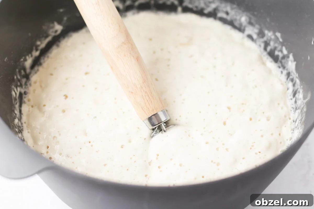Mixing homemade Italian bread dough. Mixing bread dough in a grey bowl.