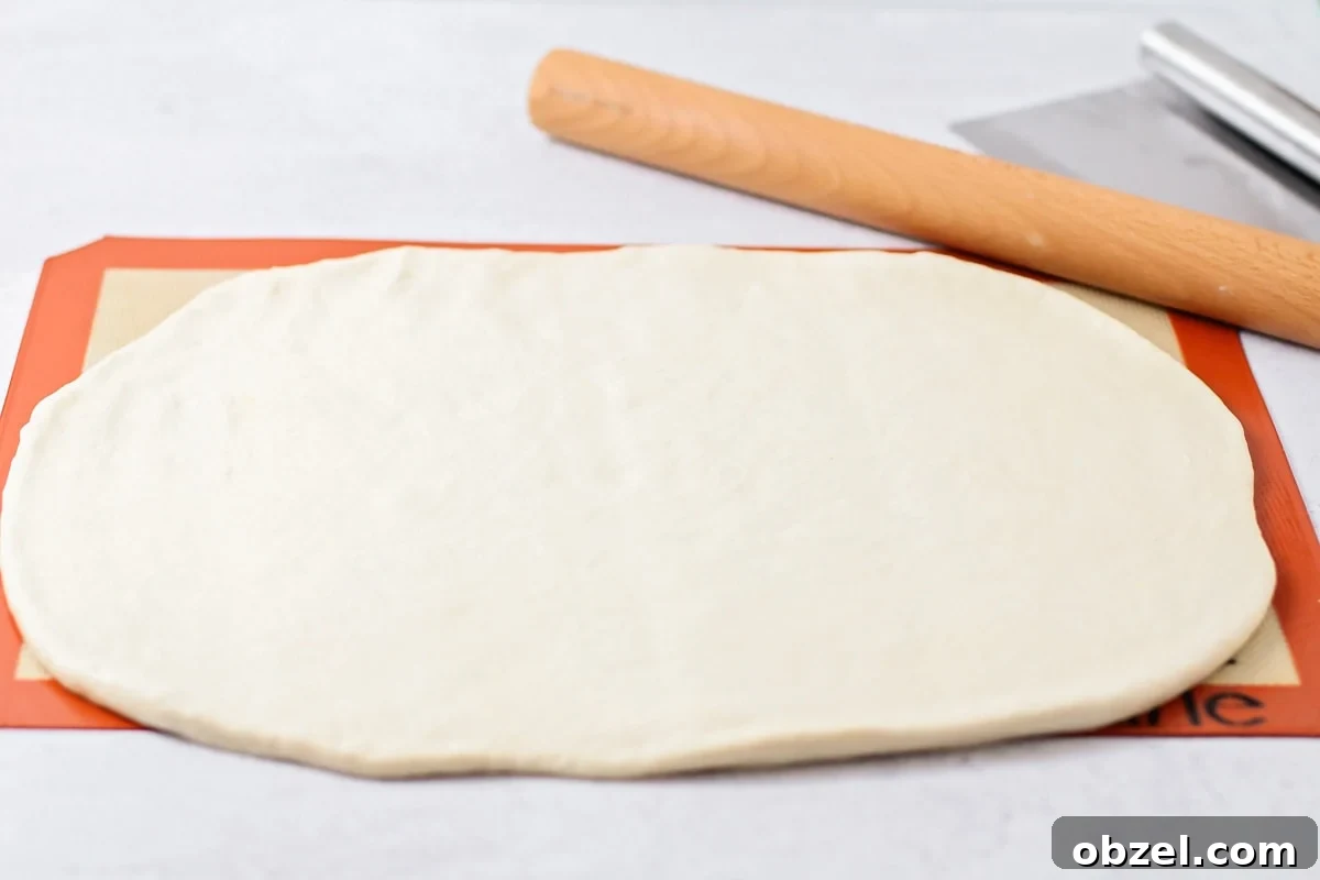 Rolling Italian bread dough. Rolling the dough flat on a silpat mat.