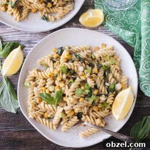 Plate of creamy sweet corn pasta topped with basil leaves.
