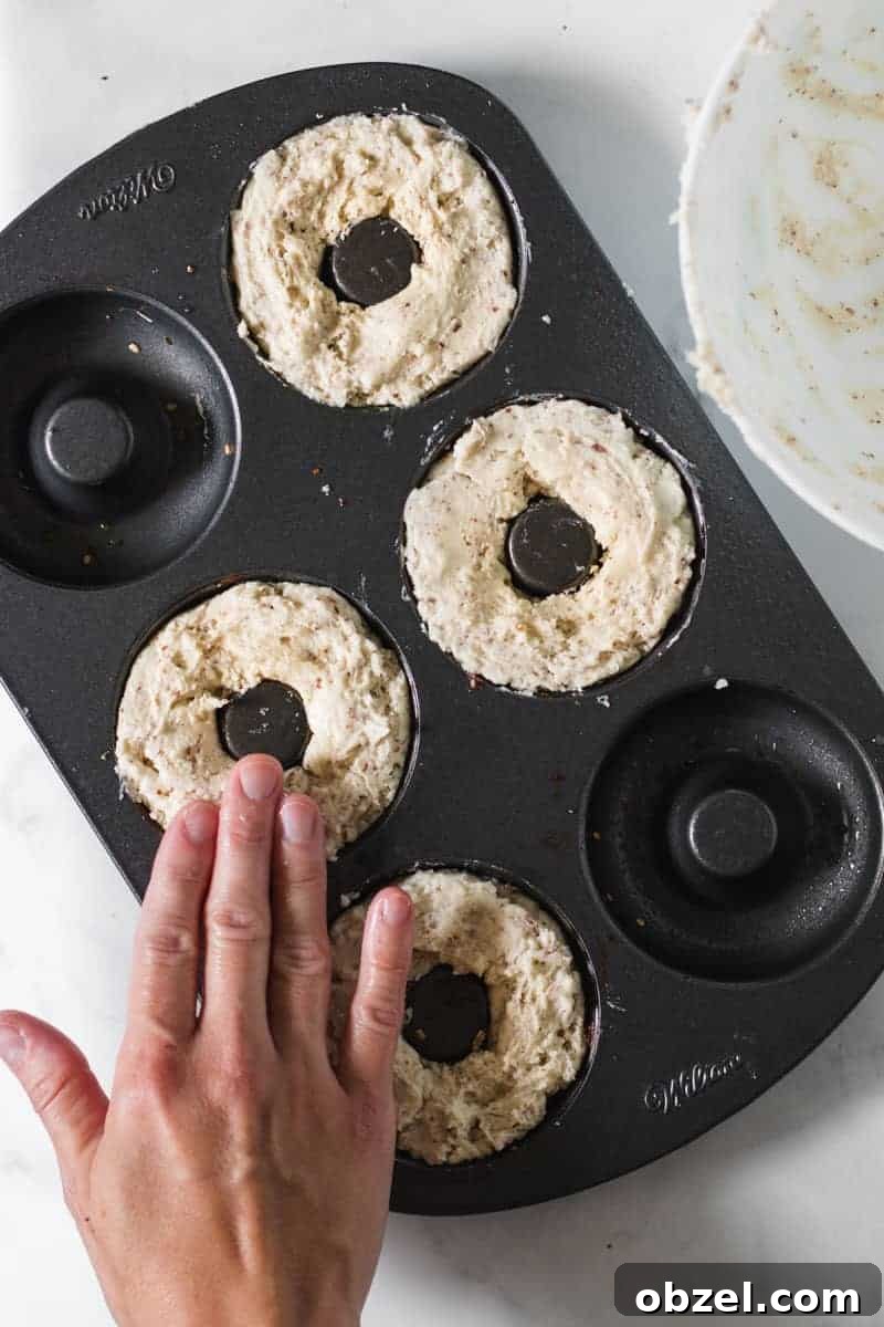 2-Ingredient Gluten-Free Bagels Recipe 5 Bagel mixture spooned into a donut pan, patted down with wet fingers.