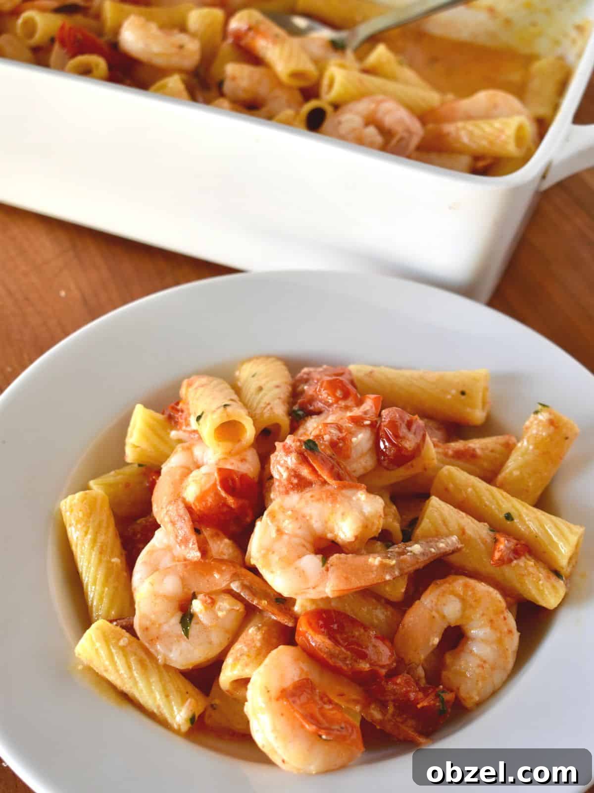 Creamy Baked Feta Pasta with Garlic Shrimp 2 Baked Feta Pasta with Shrimp in a white bowl with a white casserole dish in the background.