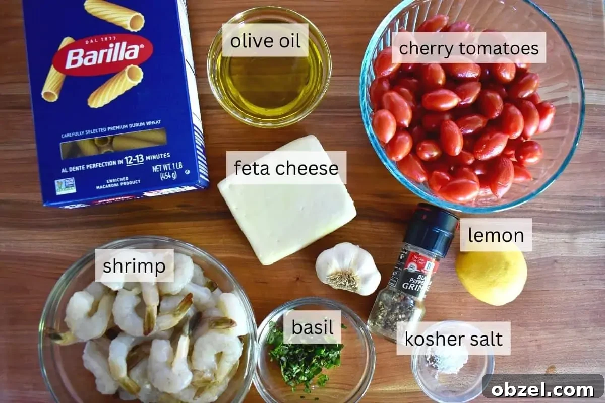 Creamy Baked Feta Pasta with Garlic Shrimp 4 overhead photo of ingredients including tomatoes, lemon, rigatoni, and olive oil.