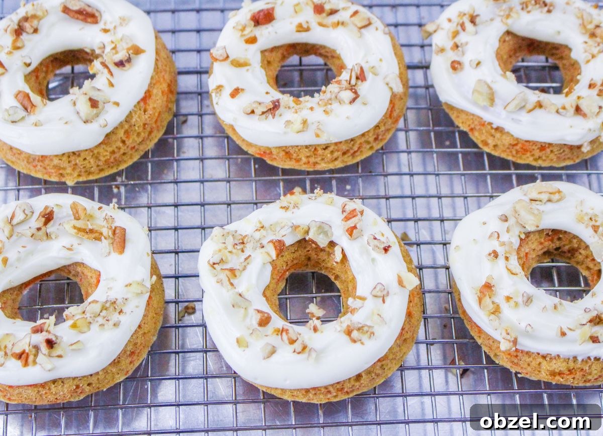 Gluten and Dairy-Free Baked Carrot Cake Donuts 2 A few gluten and dairy free baked carrot cake donuts with nuts on top.