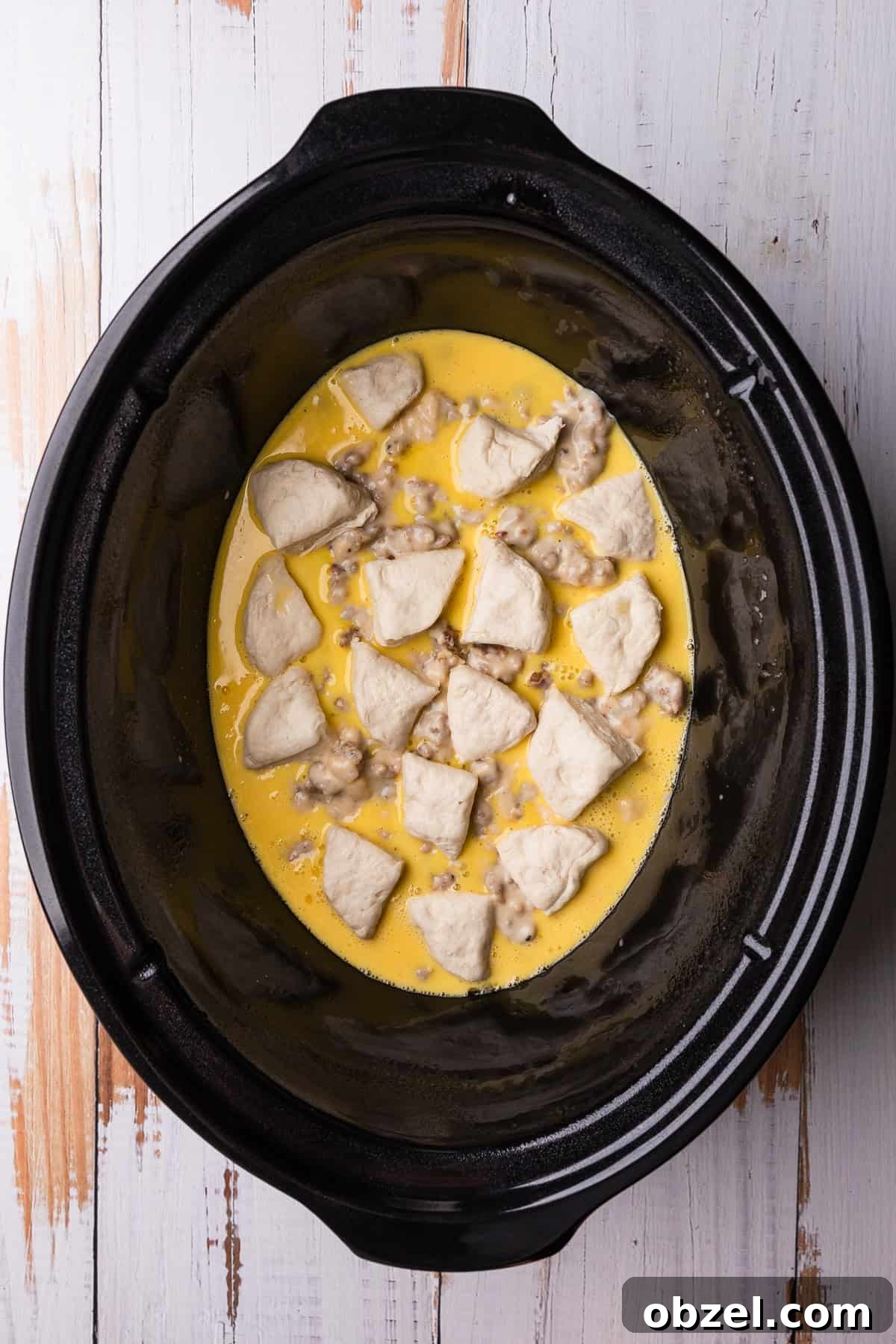 Slow Cooker Biscuits and Sausage Gravy Casserole 10 Adding the second layer of biscuits.
