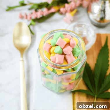 Cannabis Coconut Almond Bliss Balls Recipe 13 A white counter top with a gold spoon and a glass jar filled with cannabis butter mints.