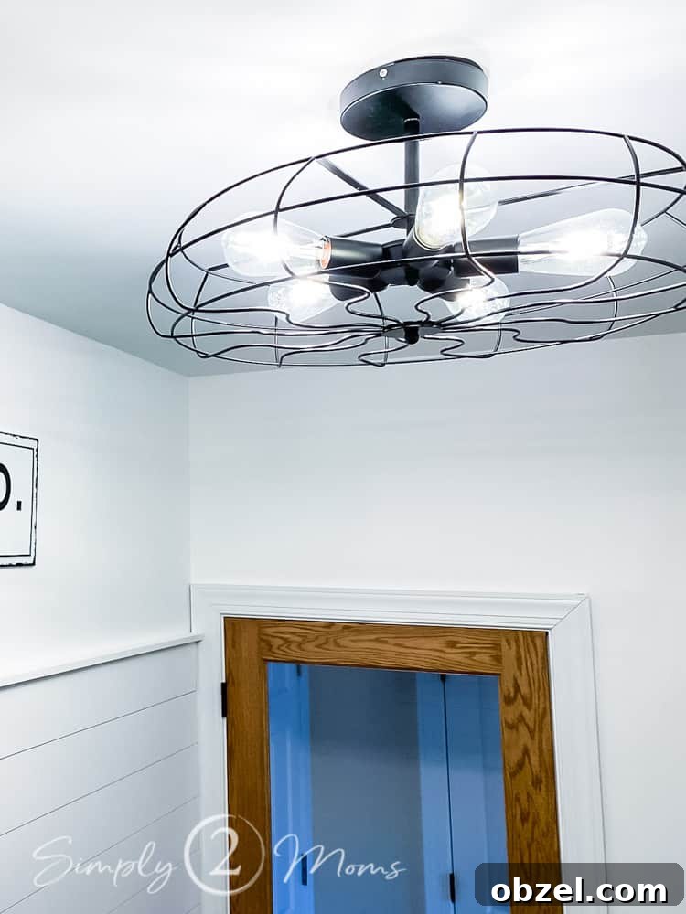 Stunning Before and After Laundry Room Makeover 16 close up of industrial light with caged style cover and 5 light bulbs hanging on ceiling in laundry room