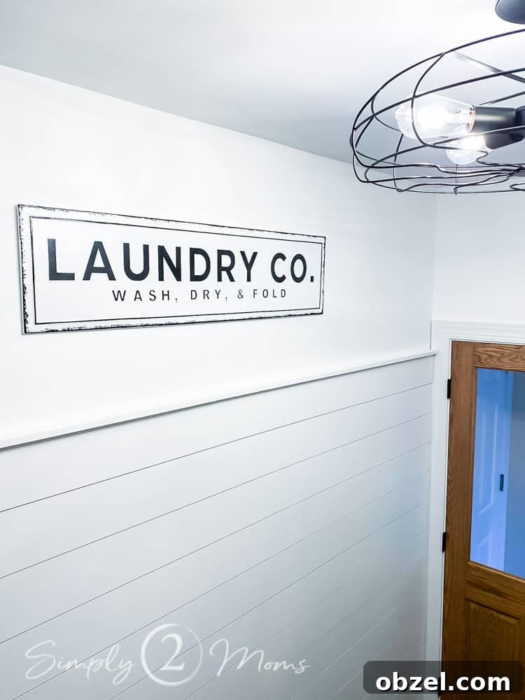 Stunning Before and After Laundry Room Makeover 19 long metal sign that read laundry co wash dry fold hanging on wall above shiplap