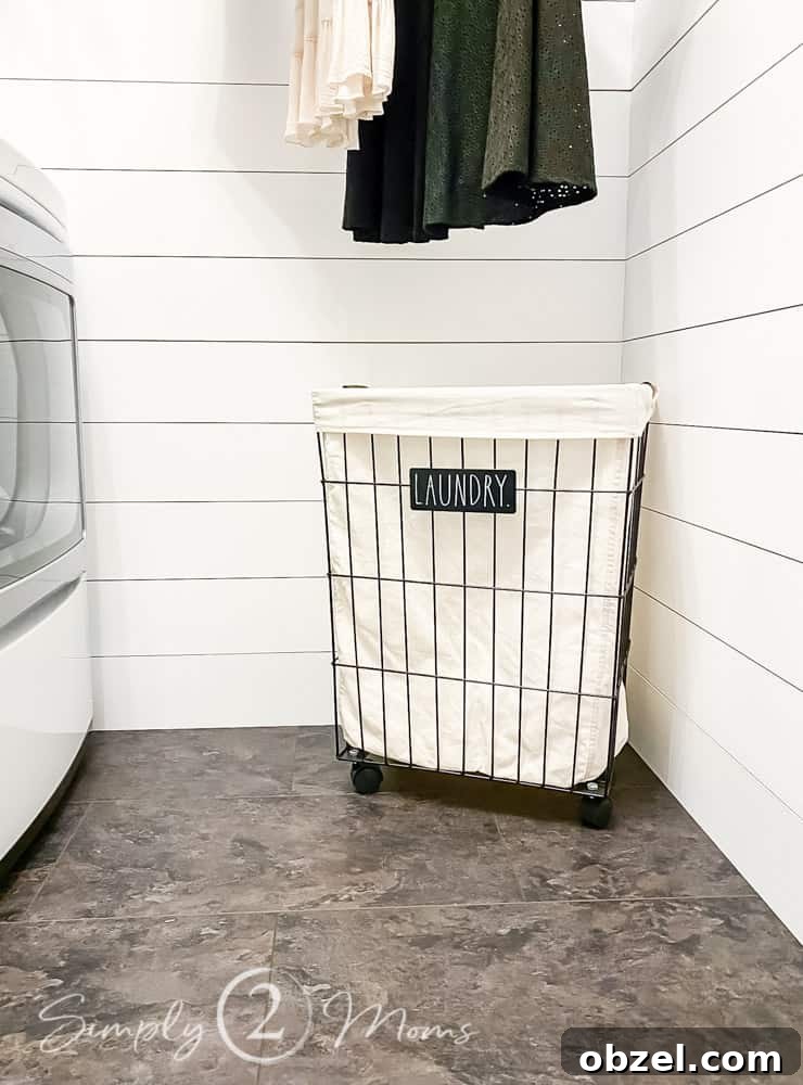 Stunning Before and After Laundry Room Makeover 8 metal rolling hamper with fabric liner on floor with hanging clothes above