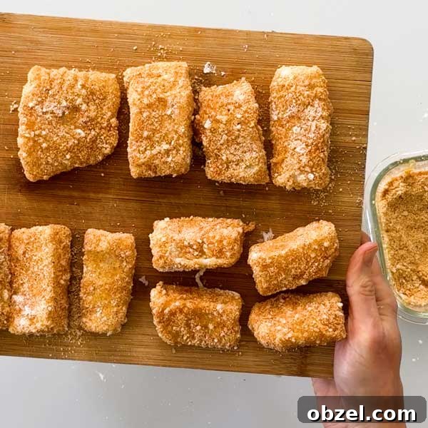 Gluten Free Breaded Fish with Homemade Tartar Sauce 7 Breaded cod on a cutting board.