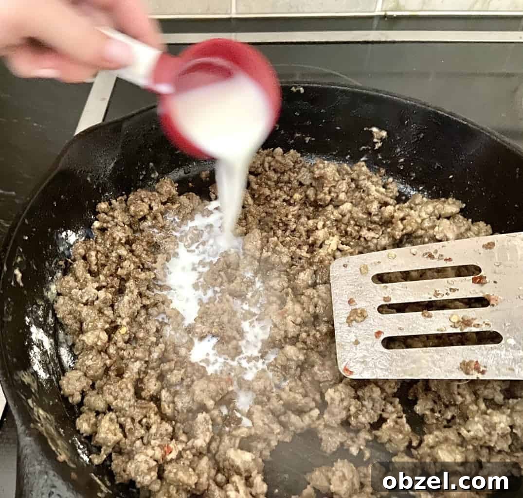 Creamy Sausage Gravy Recipe 4 Milk being added to cooked sausage and flour