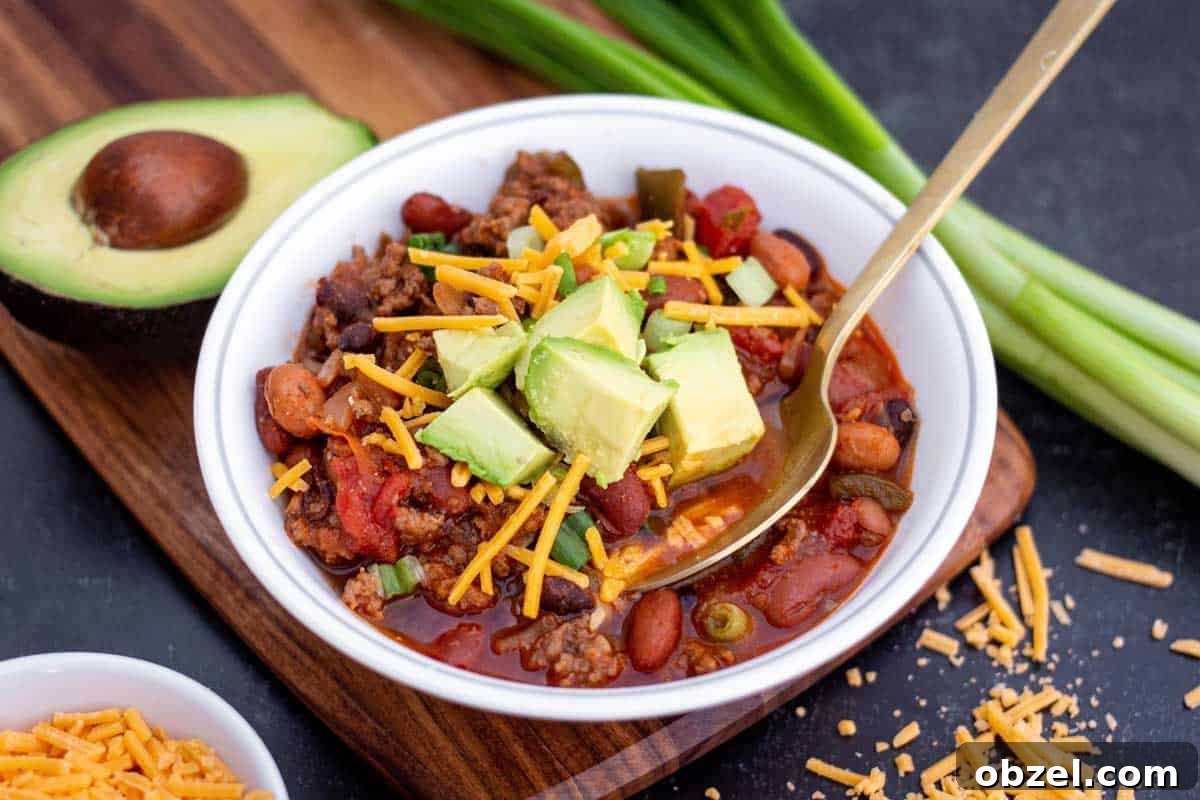 Why Meal Planning Feels Hard and Shortcut Cooking Helps 4 Small bowl of ground beef and sausage chili with shredded cheddar and diced avocado on top.