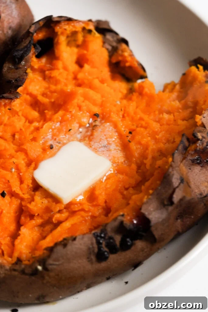 Air Fryer Baked Sweet Potato with Crispy Skin 2 air fryer sweet potato cut open with butter, salt, and pepper