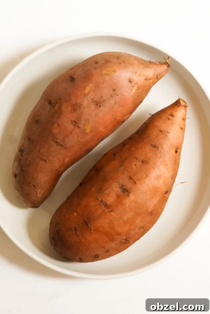 Air Fryer Baked Sweet Potato with Crispy Skin 4 two sweet potatoes on a plate