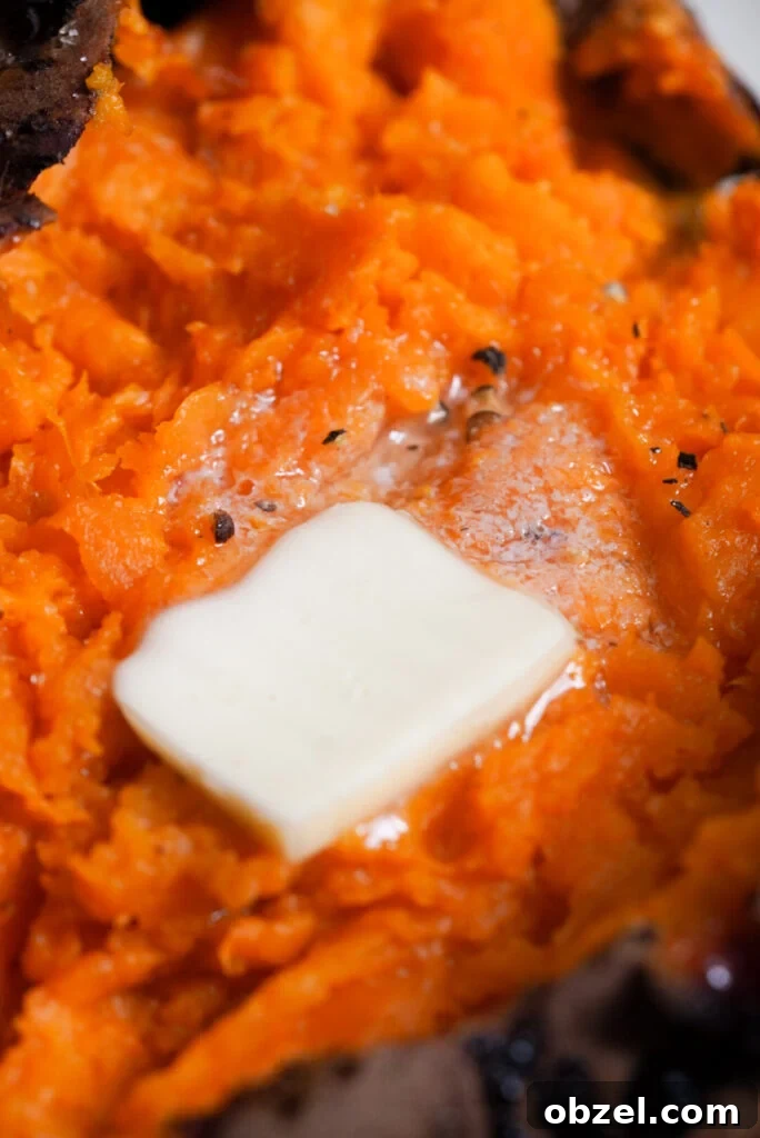 Air Fryer Baked Sweet Potato with Crispy Skin 9 close up shot of sweet potato flesh with butter, salt, and black pepper