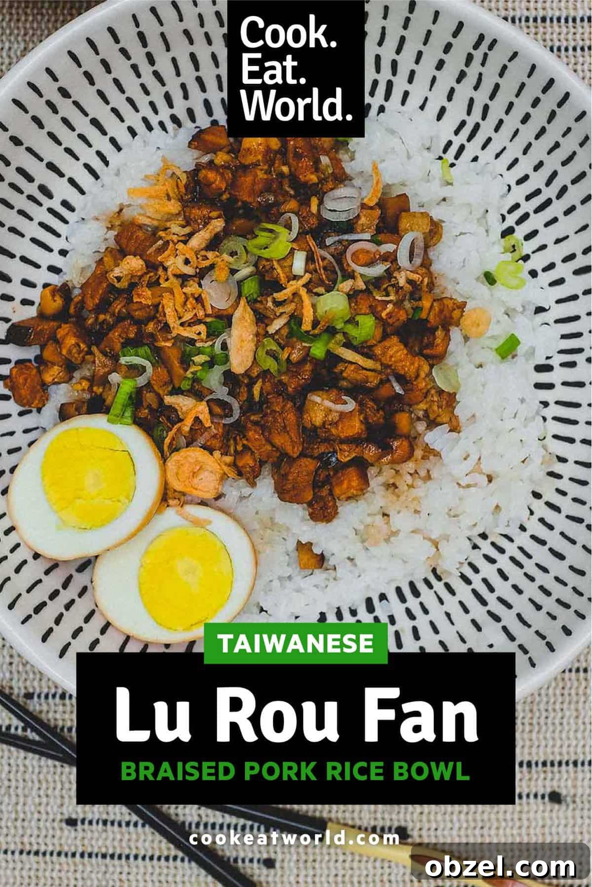 A bowl of Taiwanese braised pork (Lu Rou Fan) on a bed of rice with two egg halves, crispy onion and spring onions as a garnish.