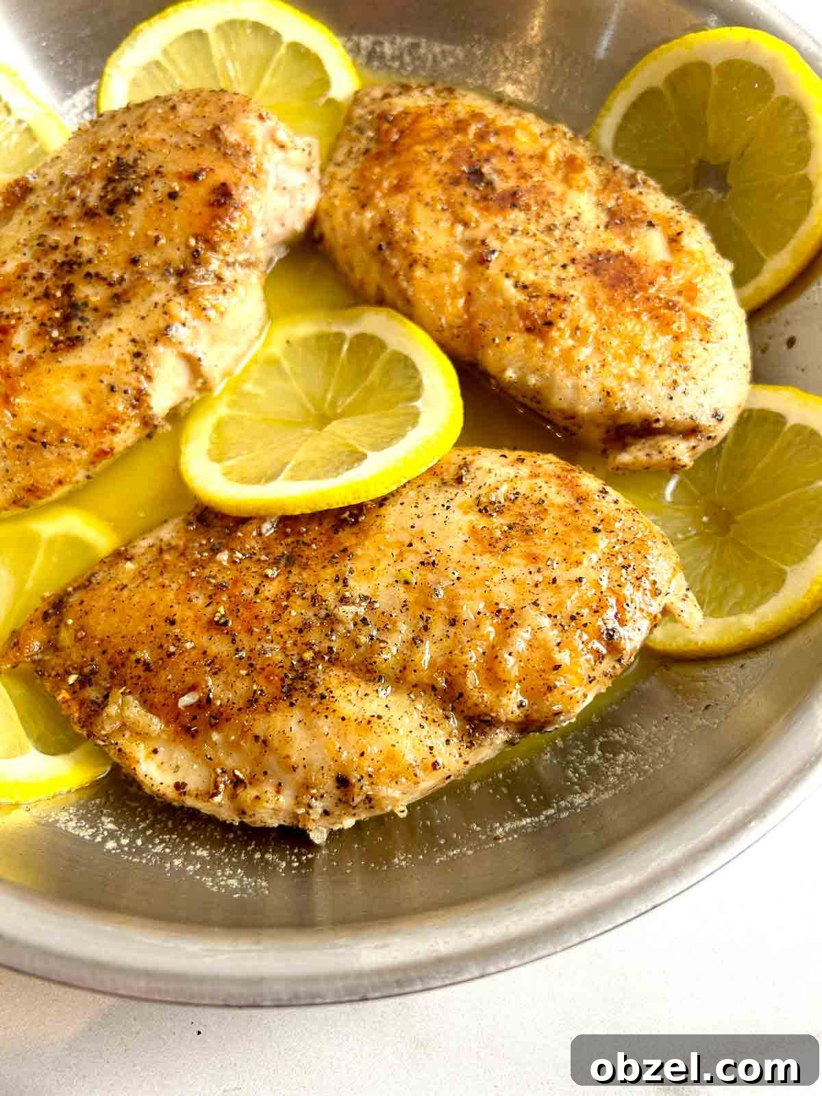 Juicy Lemon Pepper Chicken Breasts Recipe 4 close up of lemon pepper chicken cooking in pan.