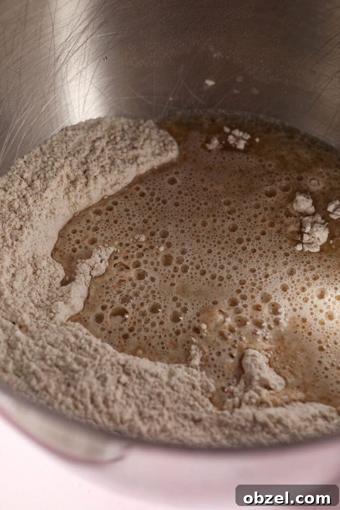 Pizza ingredients in the bowl of a stand mixer before mixing