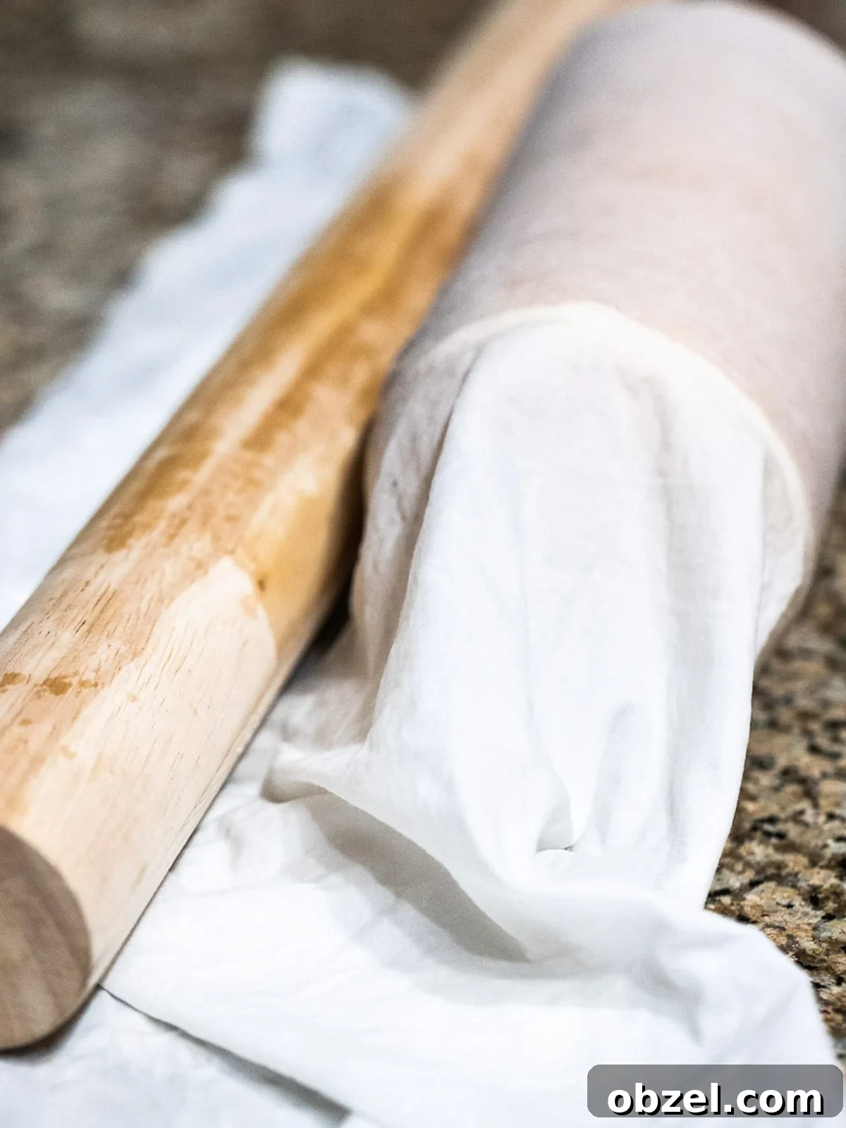 Bakery Style Swiss Roll Cake Recipe 11 Swiss roll cake rolled in kitchen cloth with rolling pin.
