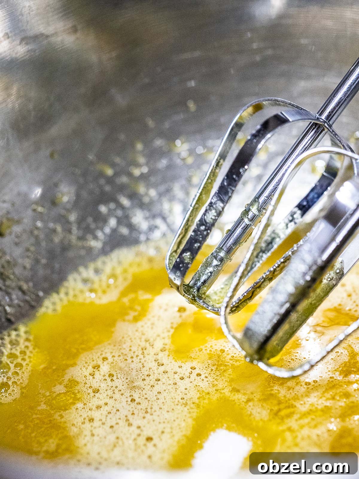 Bakery Style Swiss Roll Cake Recipe 5 Egg yolk with a whisk in a metal bowl.