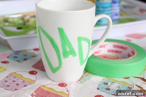 Dad spelled in painters tape on a white mug