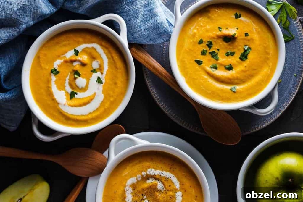 Velvety Carrot, Pumpkin and Apple Soup Recipe 2 Carrot Pumpkin Apple Soup in white bowls with wooden spoons on the side