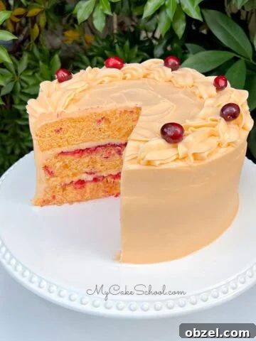 Cranberry Orange Cake, sliced, on a white cake pedestal.
