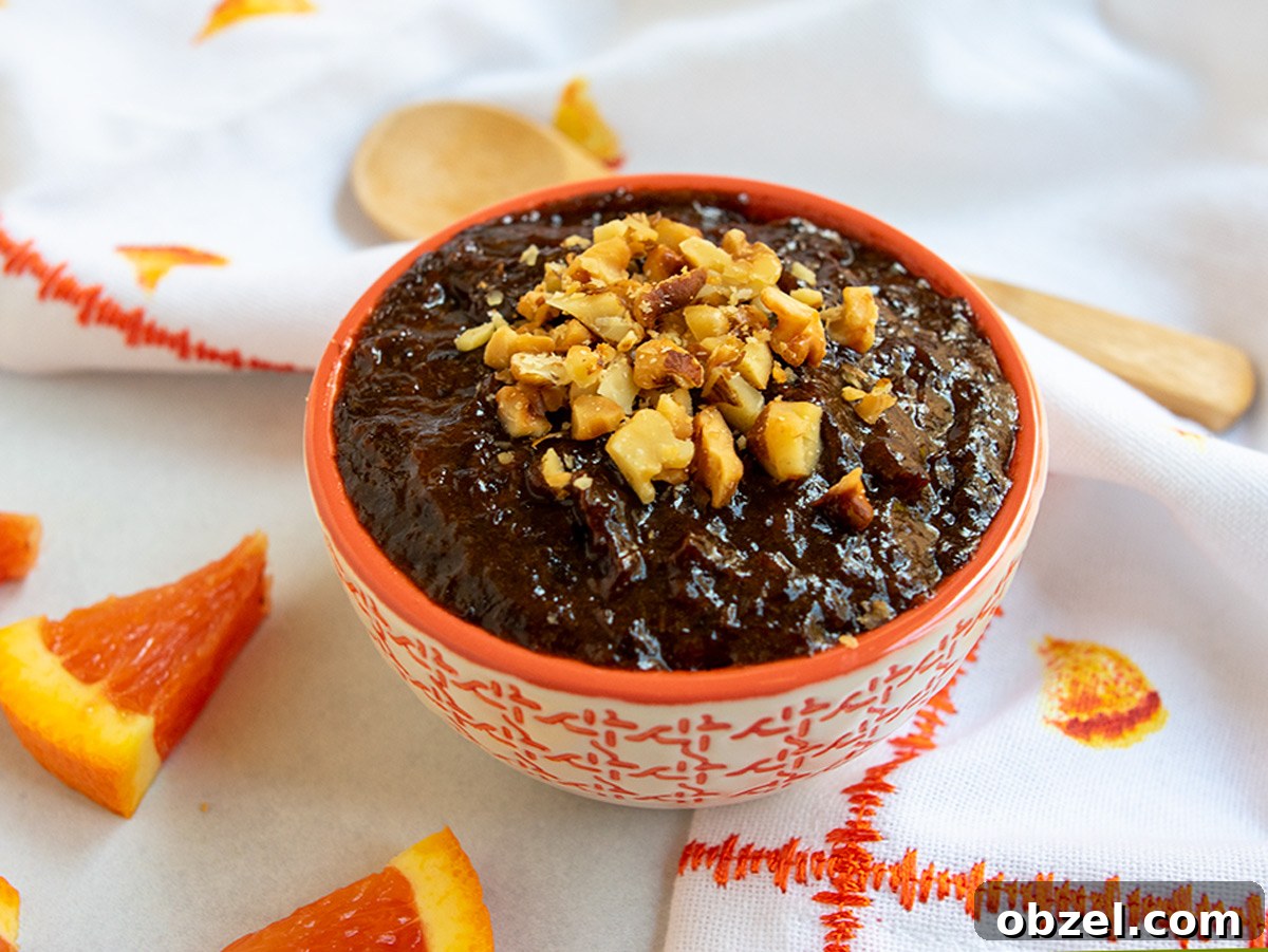 How to Make Lekvar Prune Butter at Home 12 Orange bowl of lekvar with a wooden spoon in the background.