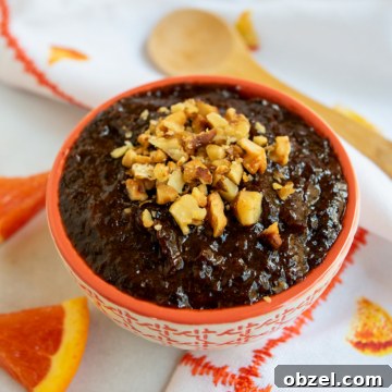 How to Make Lekvar Prune Butter at Home 14 Lekvar at an angle with chopped walnuts on top.