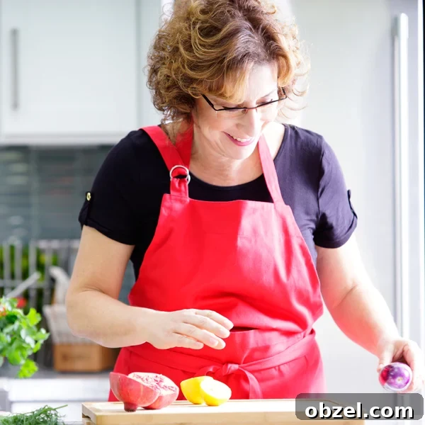 How to Make Lekvar Prune Butter at Home 15 Beth Lee in a red apron looking at vegetables on a cutting board.